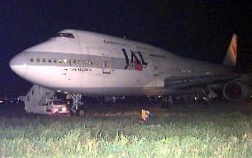 JAL jumbo gets stuck in grass at Kansai airport